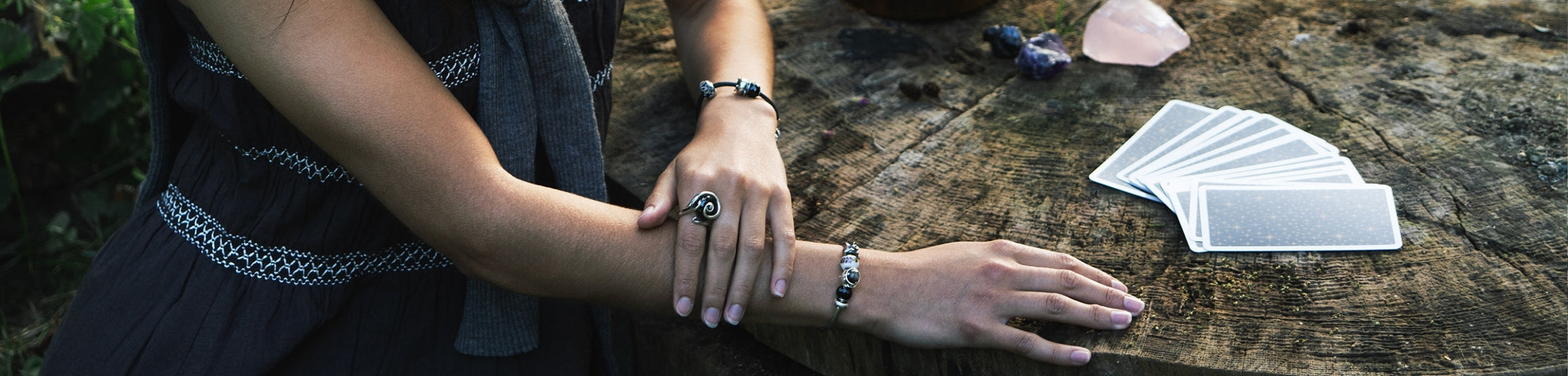 Model wearing bracelets with beads next to tarot cards