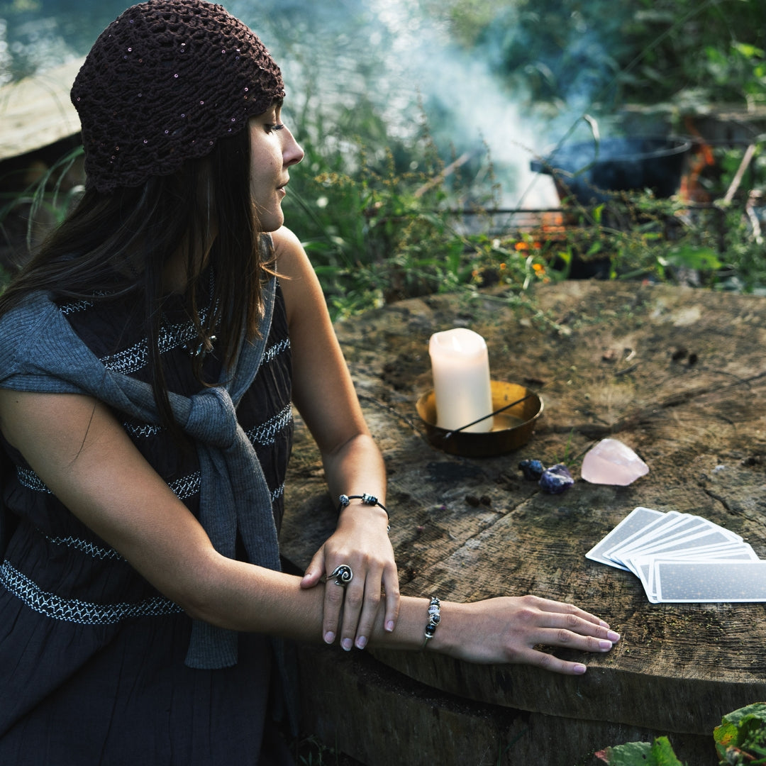 Model wearing bracelets with beads next to tarot cards